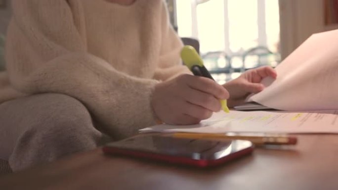 学生舒适地坐在家里，在文字上划线。