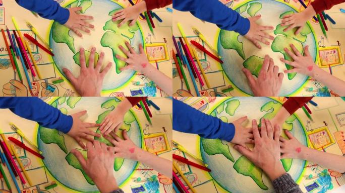 孩子们和老师的手紧紧握住他们关于可持续性的艺术