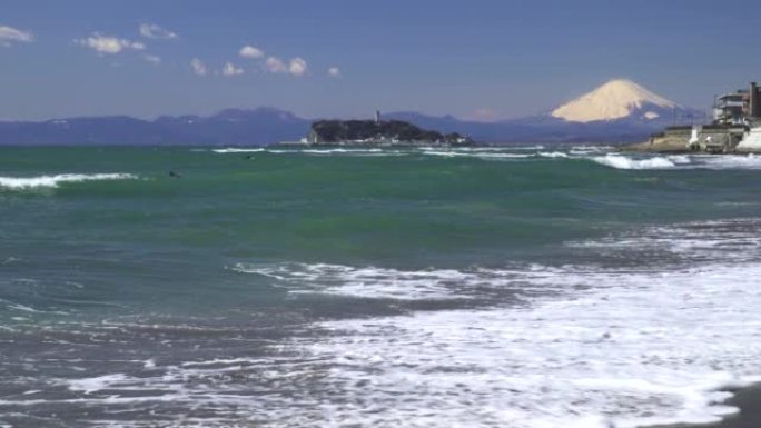 海浪拍打着海滩、江之岛和富士山。