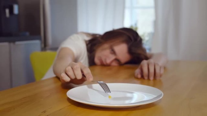 厌食症的年轻人有意识地选择饮食，将玉米粒放在盘子上
