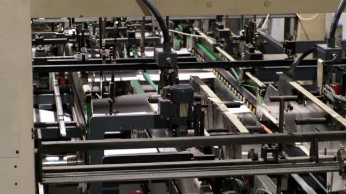 生产纸箱的工厂。自动折叠和胶合线。传送带上的纸板箱
