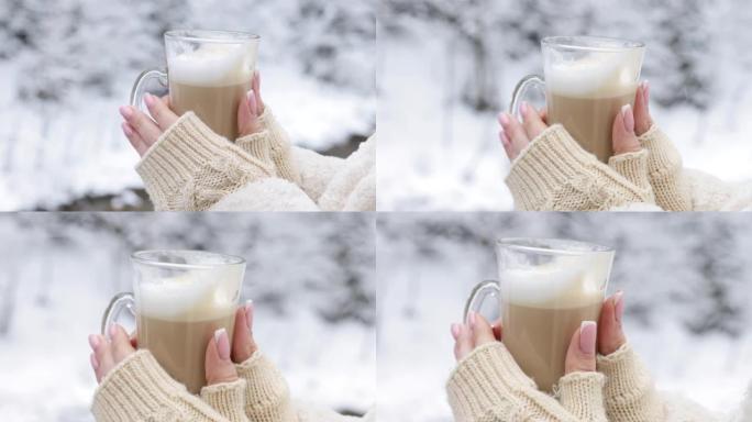 美丽的手，完美的修指甲，在一个下雪的冬天的早晨拿着一杯lats。指甲护理