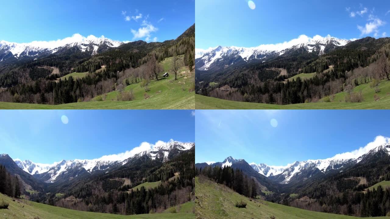 奥地利卡林蒂亚卡拉万克斯春天高山充满活力的绿色草地的全景。高山铁链被积雪覆盖。查看Hochstuhl