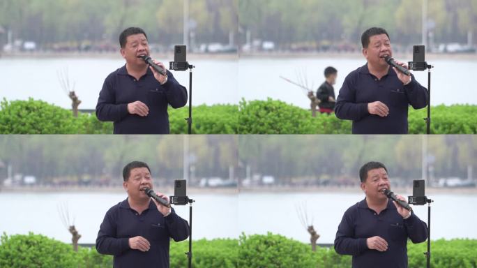 公园里中年男人对着手机唱歌娱乐