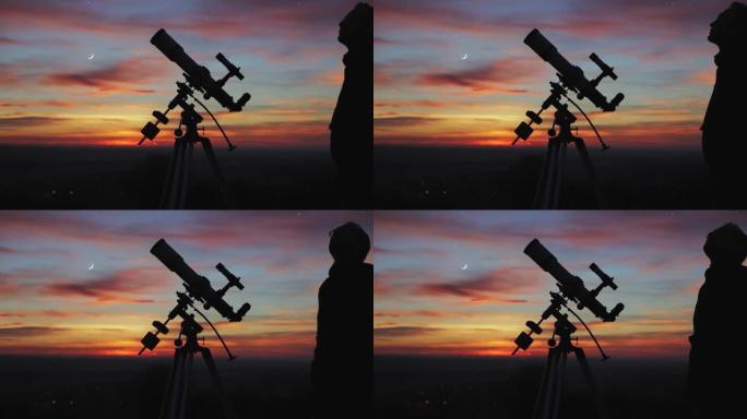 夜空下男人、望远镜和乡村的轮廓。