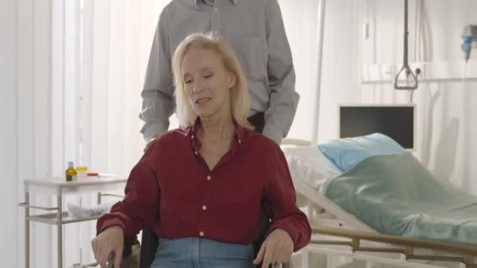 丈夫推着轮椅坐在轮椅上的高级出院女病人