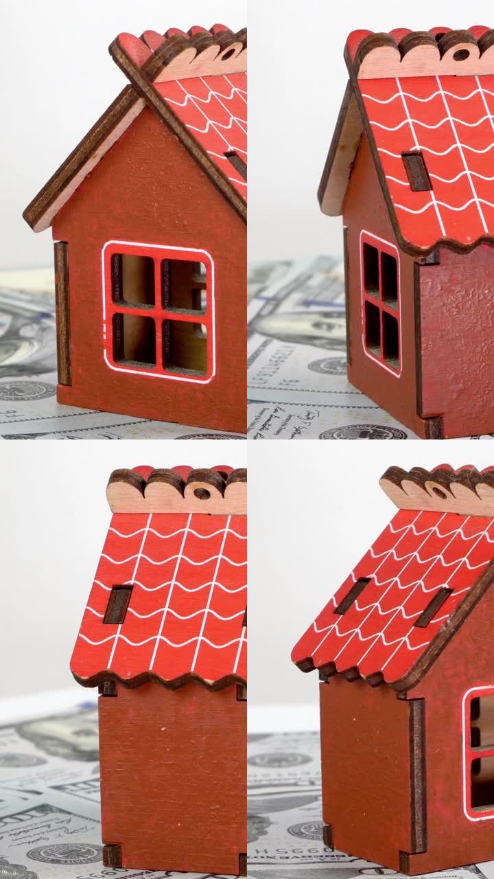 小型家庭房屋的模型站在美元钞票的背景上，并缓慢旋转。