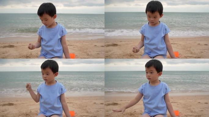 孤独的男孩坐在沙滩上