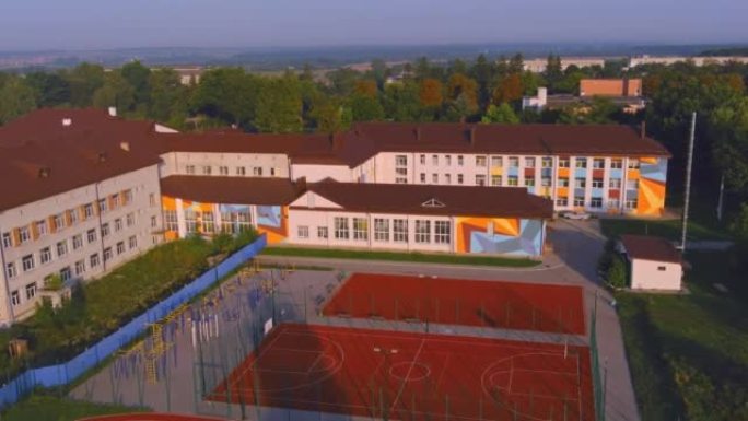 早上的校舍和校园。篮球操场部门树。游乐场