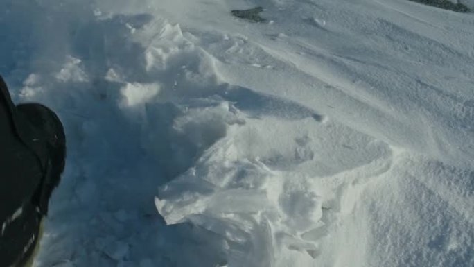 一个男人走在冰天雪地上。靴子踢到雪。美丽的冬天的风景。俄罗斯的自然地标。前视图。慢动作