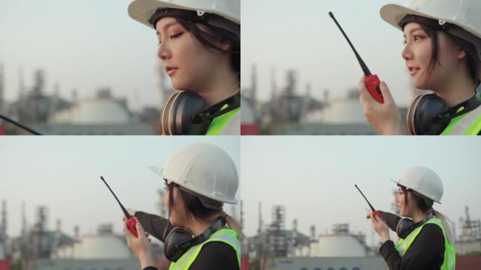 亚洲女工程师与无线电交谈，以控制建筑工作。