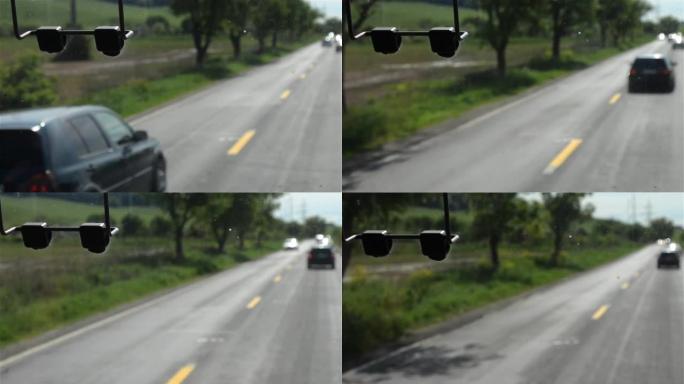 通过公共汽车的挡风玻璃看到的图像，该公共汽车在有两条车道的道路上快速行驶