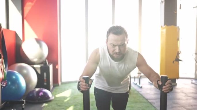 有胡子的男运动员在健身房进行的举重车训练