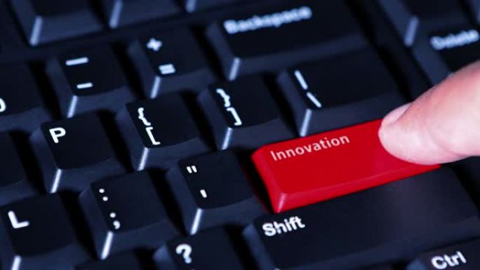 人手特写按下电脑键盘上的红色创新按钮