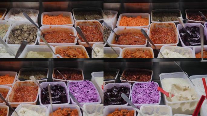 以色列特拉维夫市场上出售的用白菜，胡萝卜和不同蔬菜制成的沙拉的特写视图