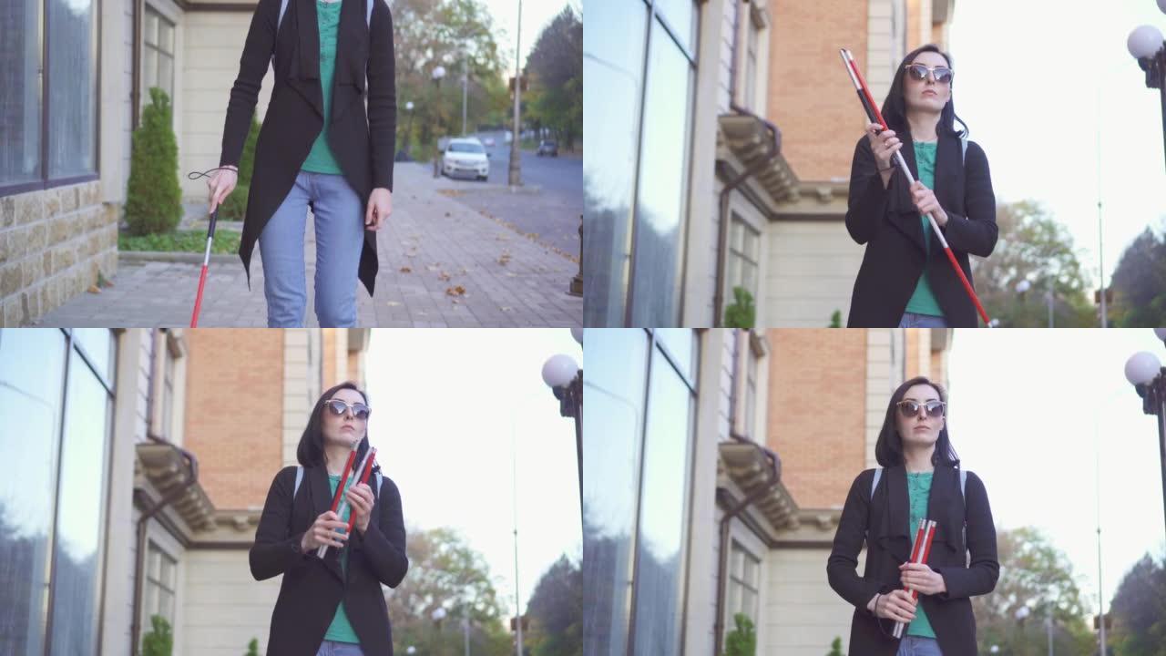 一个年轻的盲人漂亮的女人，戴着眼镜，拄着拐杖在街上走