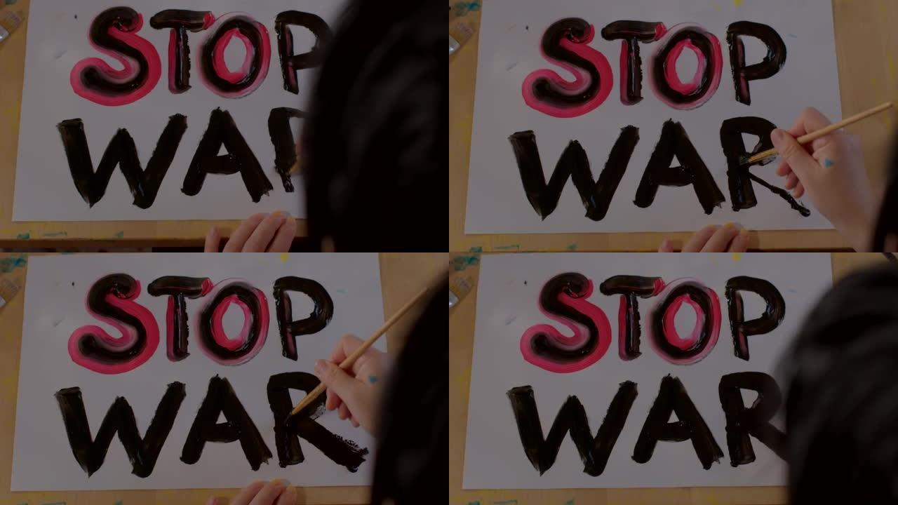 在纸上画一幅停止战争海报。孩子的手握着刷子，写了一封信。
