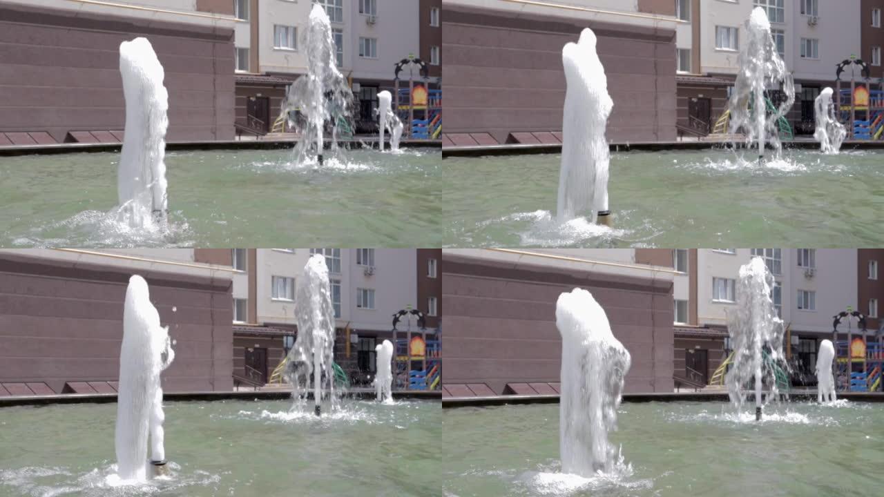 以慢动作在喷泉中飞溅或喷射水。在炎热的夏日，城市喷泉的特写镜头。水滴和飞溅在阳光下闪闪发光。水压。舞