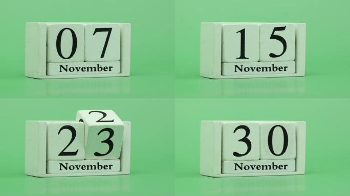11月月份日历4k停止运动通过手工木制日历在一个月内快速的时间节奏，日期月份和日期放在木桌上