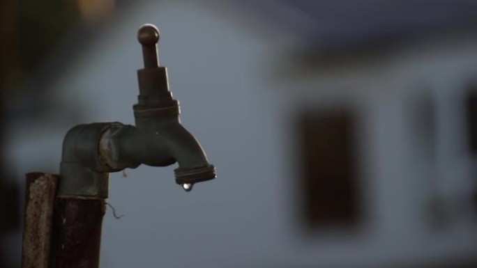 郊区房屋后院的水龙头漏水