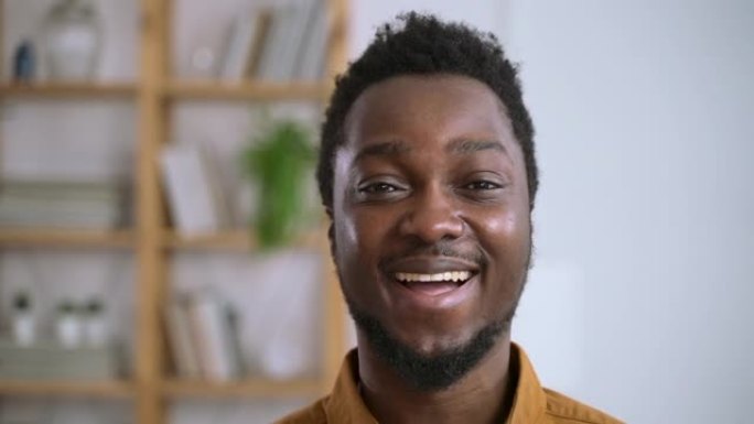 非洲男子的肖像笑了Spbas。美国20多岁30多岁男子站在家里的客厅表演