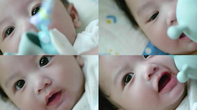 特写镜头亚洲男婴玩Sozzy婴儿出牙玩具。