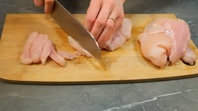木切板上的刀片鸡胸肉生白肉片