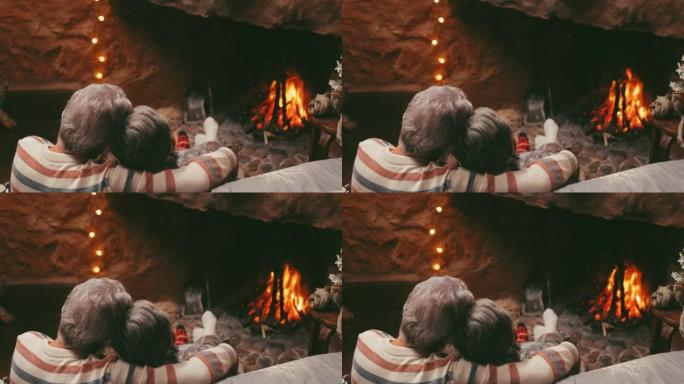 老高加索夫妇一起在家度过闲暇时光。在冬季圣诞节期间，爱浪漫的夫妻在燃烧的壁炉前牵着手放松