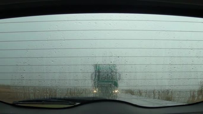 雨天在路上行驶，透过汽车后挡风玻璃