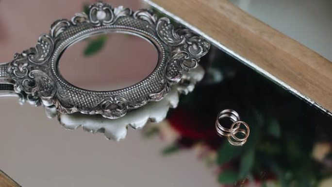 镜子旁边的桌子上有一个小镜子旁边的金戒指