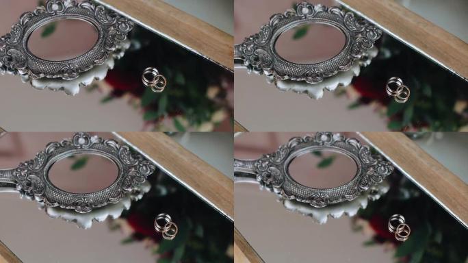 镜子旁边的桌子上有一个小镜子旁边的金戒指