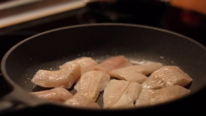 健康饮食欧米茄3。低热量白肉。主厨腌制食用鱼。用油关闭煎锅的鱼片带鱼。烤健康食品。油炸鳕鱼片配香料特
