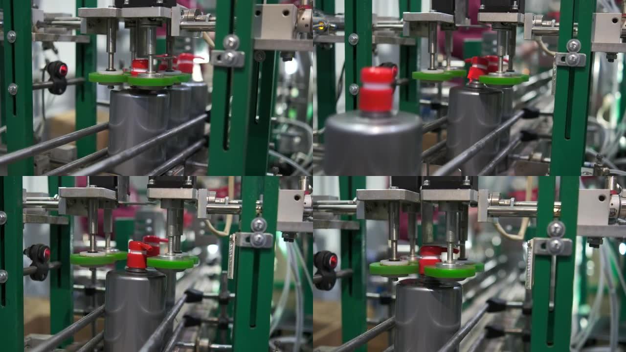 为家庭生产洗涤剂的企业。机器将带有分配器的红色塞子拧到装有液体的灰色塑料瓶上。输送线。
