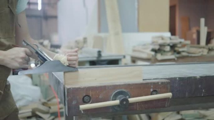 女木匠使用刨床刨木，工作场所。慢动作
