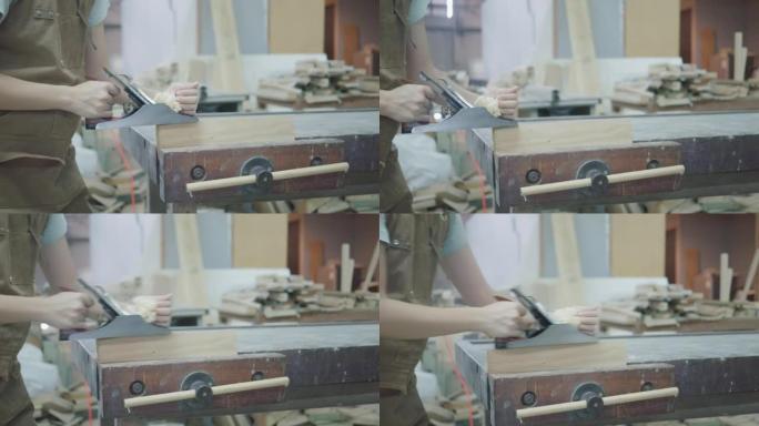 女木匠使用刨床刨木，工作场所。慢动作
