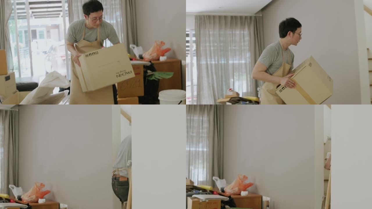 亚洲男子搬到新房子时拿着盒子