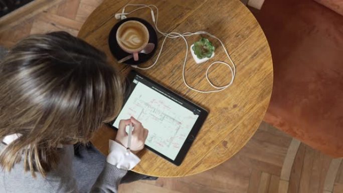 无法识别的高加索女性建筑师在数字平板电脑上勾勒蓝图