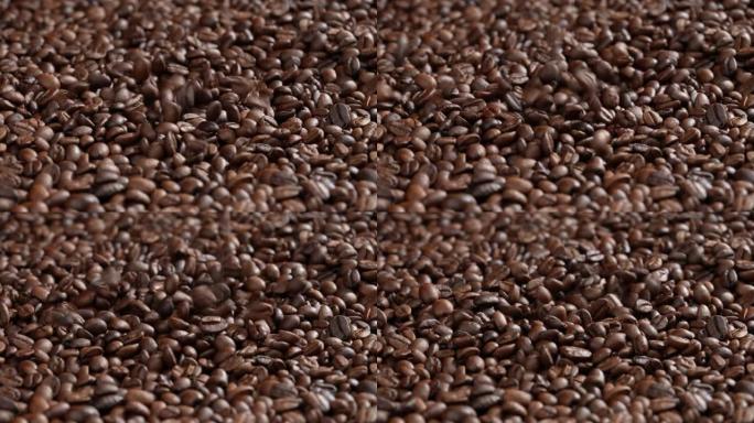 烤咖啡豆落入一堆咖啡豆。一大堆新鲜烘焙的浓郁芳香咖啡豆。慢动作。