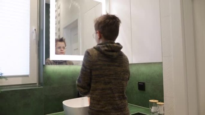十几岁的男孩在绿色浴室洗手