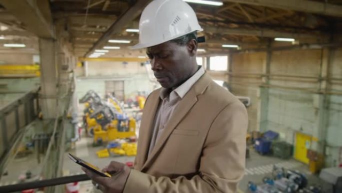 非裔美国工程师在工厂使用智能手机