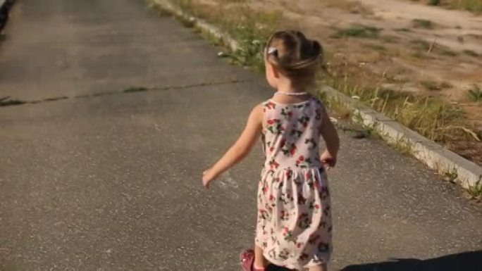 夏天的一天，两岁的女孩在公园的跑道上跑步