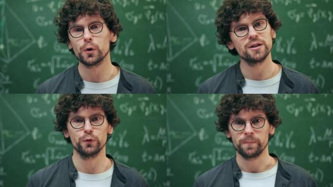 肖像中年时尚的老师对着镜头说话，解释他身后黑板上写的数学公式。男讲师在大学教室与学生交流