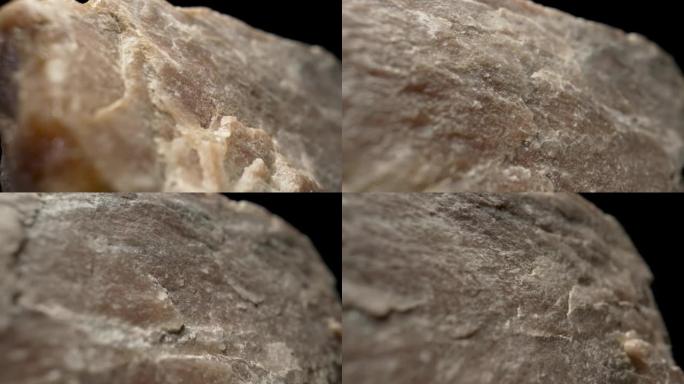 黑色背景下的实心花岗岩或石英石。天然粗糙矿物。石材天然结构的背景。地质学、矿石开采、建筑材料的概念。