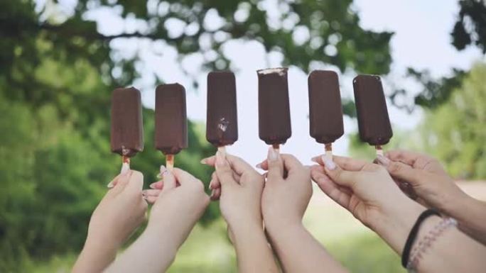 朋友连续将巧克力冰淇淋放在棍子上