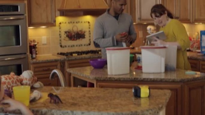 在厨房一起烹饪年轻的多元文化家庭父亲和母亲带着孩子的生活方式与科技视频系列
