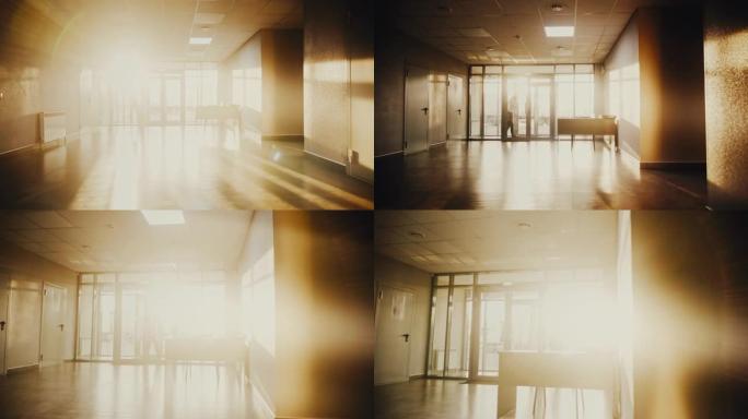 男人在明亮的阳光下在大厅里走路和打电话的剪影