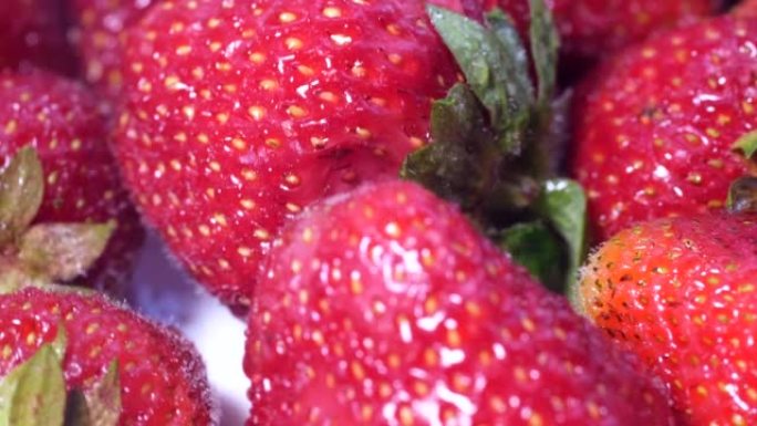 美丽栽培深红色草莓草莓大团旋转特写。