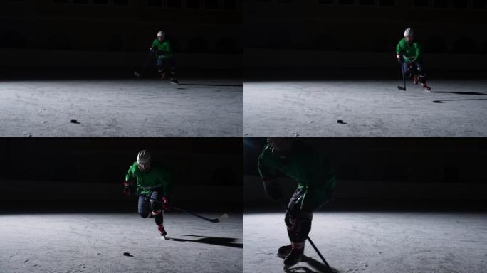 身穿绿色制服，双手戴着一根棍子的头盔在冰上滑行并击中冰球。运动员在背光的黑暗竞技场的冰上滑冰。慢动作