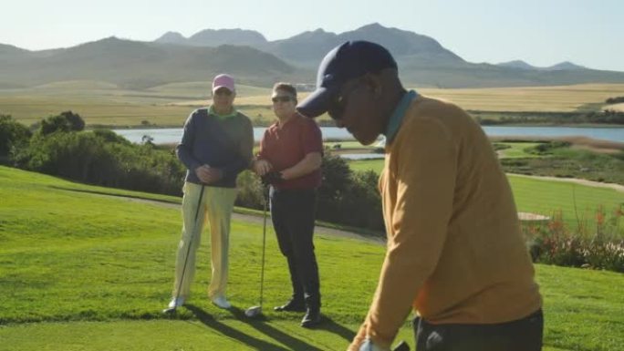 男性高尔夫球手在阳光明媚的高尔夫球场上开球
