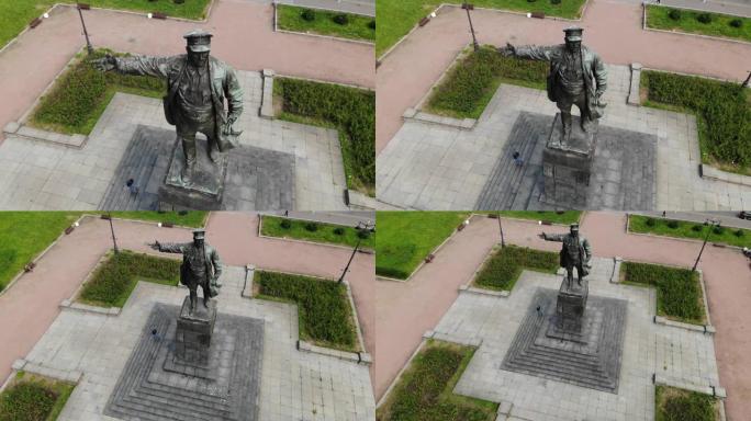 列宁纪念碑在一个有鸽子的基座上。戴着帽子伸出手的男人